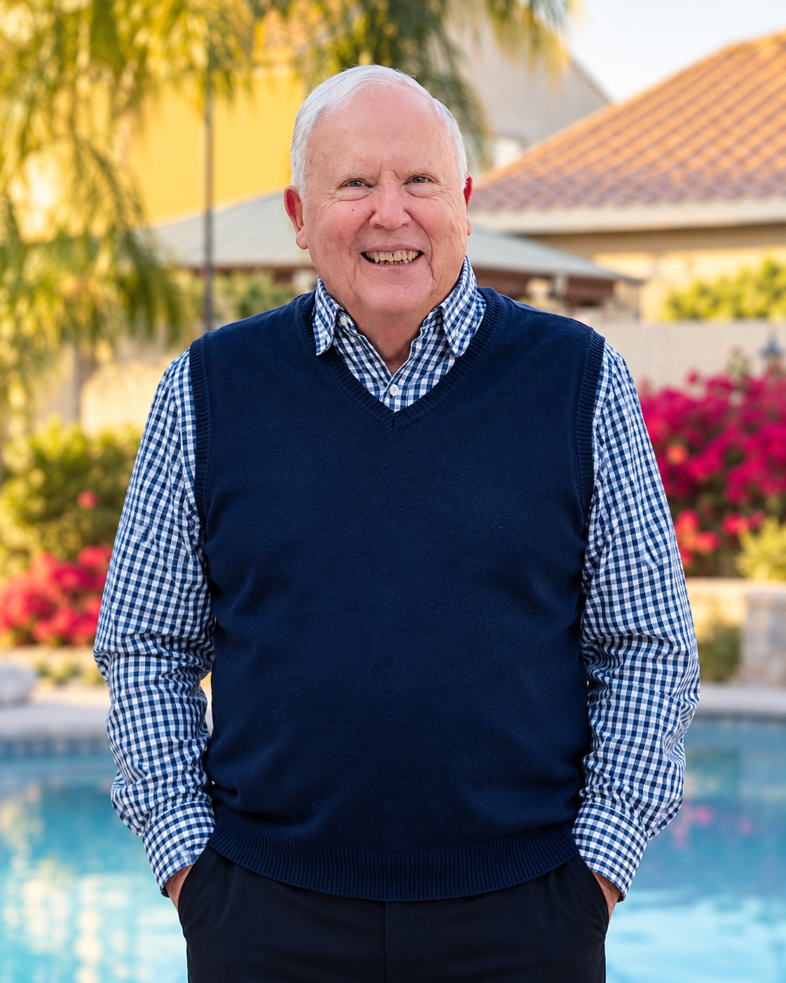 Mel Stewart smiling, wearing a navy sweater and a blue checked shirt